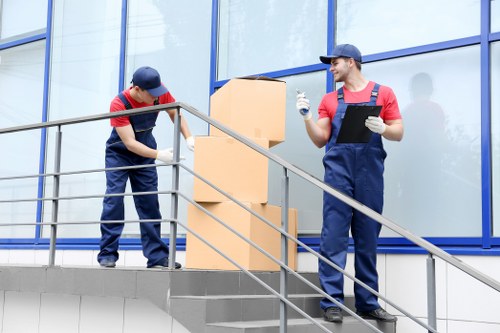 Staff member wearing PPE while loading items for a removal job